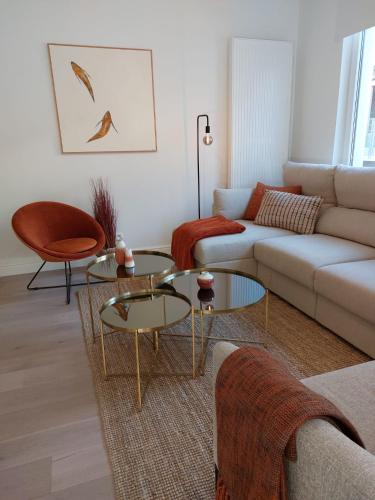 een woonkamer met 2 tafels en een bank bij Etoile de Mer in Blankenberge