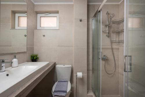 a bathroom with a toilet and a sink and a shower at Urban Residences Chania in Chania Town