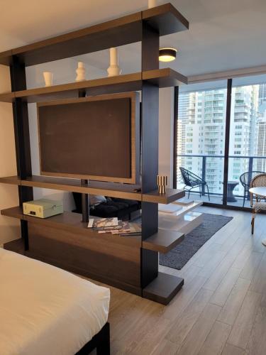 een woonkamer met een grote televisie in een kamer bij Lovely Condo Unit in Miami