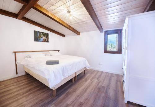 1 dormitorio con cama y techo de madera en Finca Ecológica Ferrera. Alojamiento Rural., en Arafo