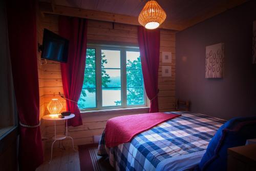 a bedroom with a bed and a window at Manoir du Lac Sept-Îles in Saint-Raymond