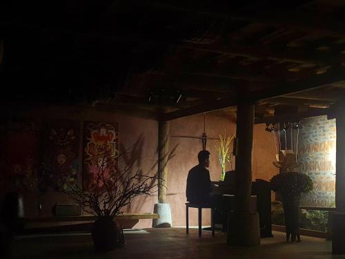 a man sitting at a table in a dark room at Mô he in Sơn Tây