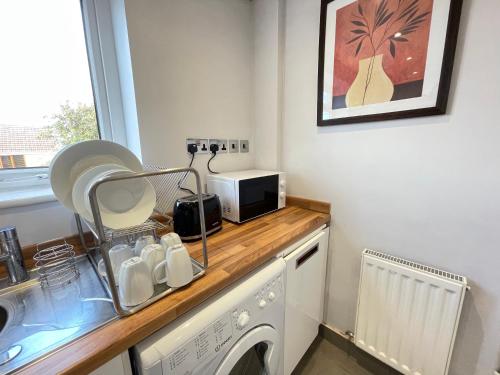 a kitchen with a washing machine and a microwave at Durham Eastside Professional Let - Durham city in Ushaw Moor