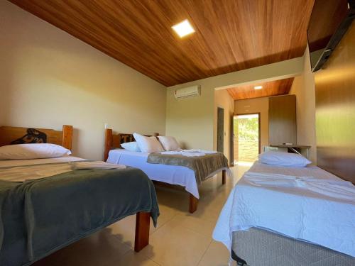 a room with three beds in a room at Tijota Hotel Fazenda in Ipatinga