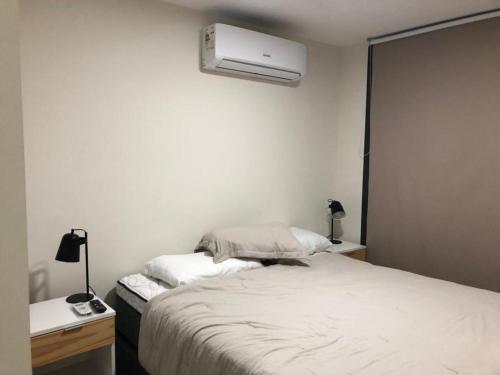1 dormitorio con 1 cama y aire acondicionado en la pared en Cómodo apartamento frente al Mar, en Piriápolis