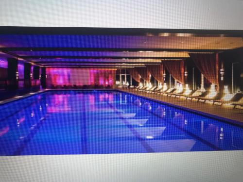 a large swimming pool with chairs in a building at Alpin Apart Hotel Poiana Brasov2409 in Braşov