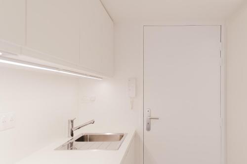 une salle de bain blanche avec un lavabo et un miroir dans l'établissement les Suites de Catherine, la St Georges, à Nancy