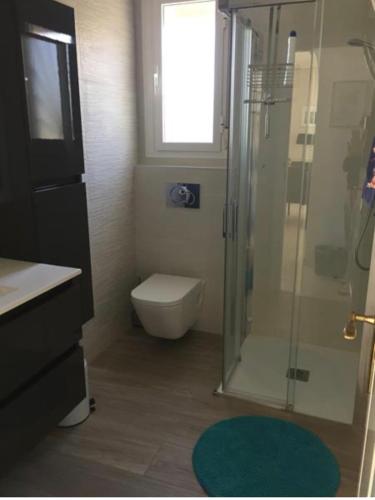 a bathroom with a shower and a toilet and a window at Casa di Paddy in Ciudad Quesada