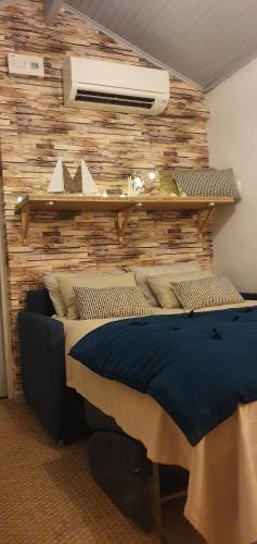 ein Schlafzimmer mit einem Bett mit einer Holzwand in der Unterkunft Mon coin de Provence petit-déjeuner offert in Roquevaire