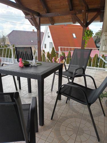 einen schwarzen Tisch und Stühle auf einer Terrasse in der Unterkunft Miranda Apartmanház in Siófok