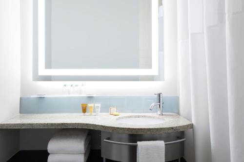 uma casa de banho com um lavatório e um espelho em Club Quarters Hotel Times Square, New York em Nova York