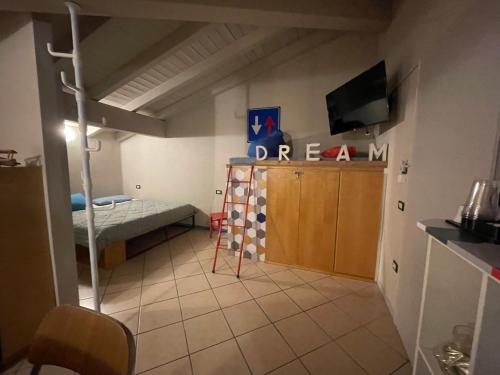 a small room with a bunk bed and a room with a television at Mansardine Metropolitane in Brescia
