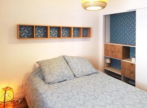 - une chambre avec un lit et une étagère avec des verres à vin dans l'établissement Appartement de charme centre ville, à La Ciotat