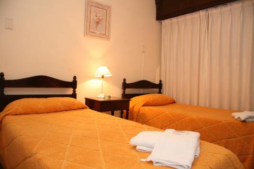 a hotel room with two beds with towels on them at Hotel Yaro in Gualeguaychú
