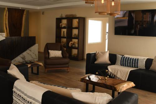 sala de estar con sofás, sillas y mesa en Hotel Dunas Near Consulate en Ciudad Juárez