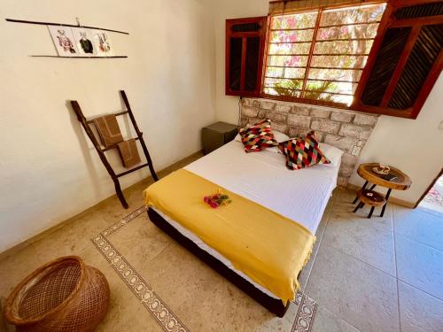 1 dormitorio con 1 cama en una habitación con ventana en Posada Gallinas en Palomino