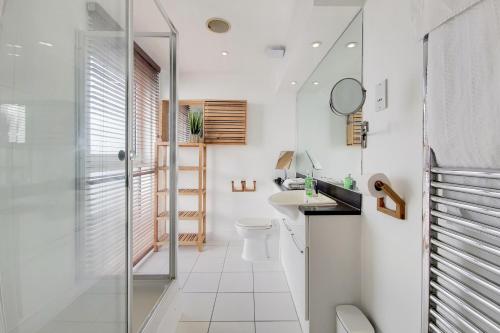 a bathroom with a shower and a toilet and a sink at Deluxe three bedroom Apartment by London ExCeL Stays in London