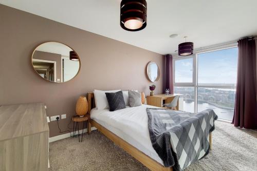 a bedroom with a large bed and a mirror at Deluxe three bedroom Apartment by London ExCeL Stays in London