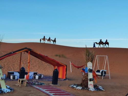 a group of people riding horses in the desert at Camel Trips Luxury Camp in Merzouga