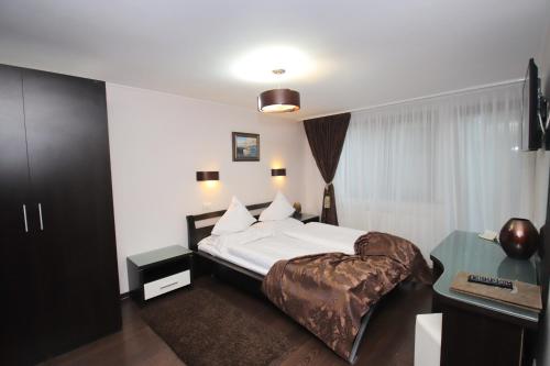 a hotel room with a bed and a desk at Complex Cochet in Buşteni