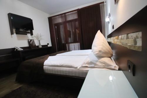 a hotel room with a bed and a television at Complex Cochet in Buşteni