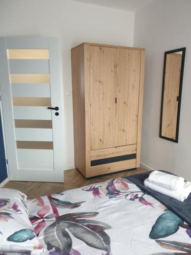 sypialnia z łóżkiem i drewnianymi drzwiami w obiekcie Modern Apartment w mieście Opole