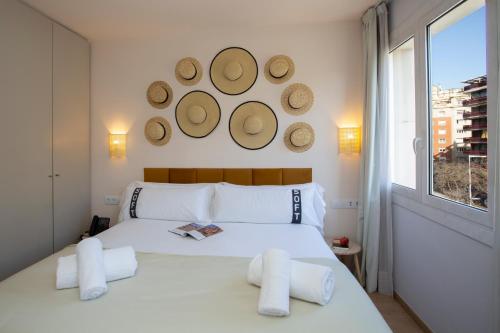 a bedroom with a bed and a window with hats on the wall at Casual Colours Barcelona in Barcelona