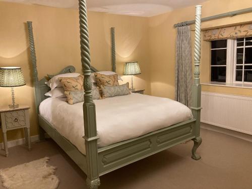 um quarto com uma cama de dossel e uma janela em The Seagrave Arms em Weston Subedge