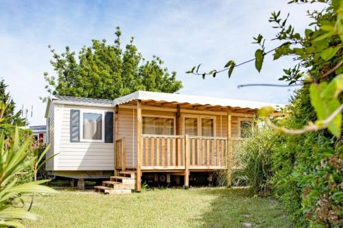 a tiny house with a deck in a yard at Mobile Home OuiReves 513 facing the Mediterranean in Lattes