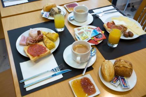 uma mesa coberta com pratos de alimentos e bebidas ao pequeno-almoço em Casual Colours Barcelona em Barcelona