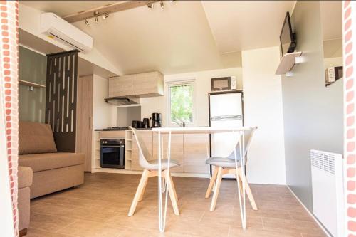 a kitchen and living room with a table and chairs at Mobile Home OuiReves 513 facing the Mediterranean in Lattes