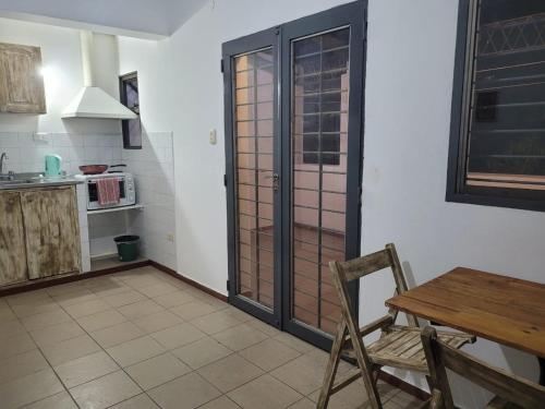 cocina con mesa y puerta de madera en Depto Céntrico II en Corrientes