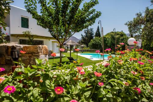 een tuin met bloemen en een zwembad bij "Palatiana Agriturismo-Philoxenia Cottages", Private Nature Retreats in Galini