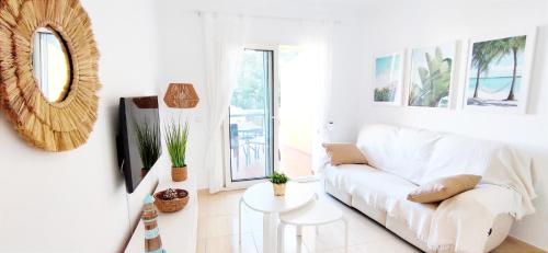 een witte woonkamer met een witte bank en een tafel bij Apartamento El Sueño II in Denia