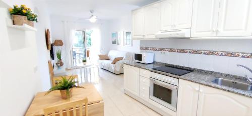 een keuken met witte kasten en een aanrechtblad bij Apartamento El Sueño II in Denia