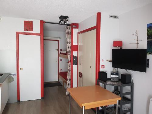 Cette chambre dispose d'une porte, d'une table et d'une télévision. dans l'établissement Studio Cauterets Résidence le Lys, à Cauterets