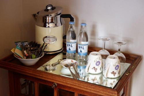 a table with a coffee maker and bottles on it at Het Domherenhuis B&B, Restaurant Calice in Heusden - Zolder