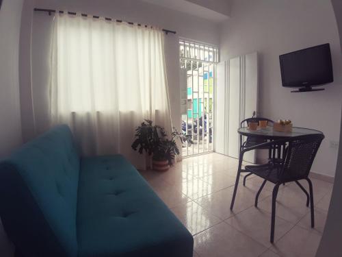 ein Wohnzimmer mit einem blauen Sofa und einem Tisch in der Unterkunft Apartamento amoblado en La Tebaida, Quindio in La Tebaida