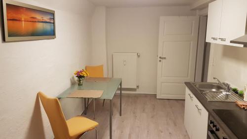 a small kitchen with a table and a sink at Urlaub im Herzen Wismars Souterrain in Wismar