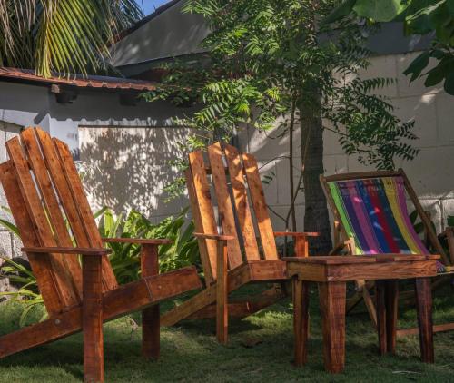 拉斯佩尼塔斯的住宿－Casita de Playa BOMALU，两张木椅,坐在画作旁边