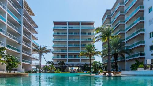 a swimming pool in front of two tall buildings at Pacifika 7007 con vista panorámica a la marina in Mazatlán