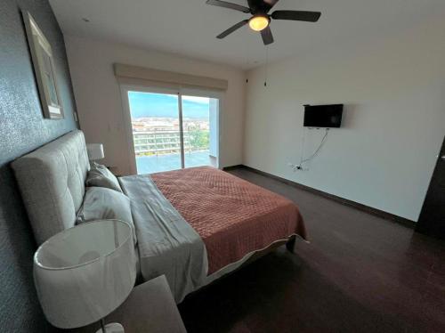 a bedroom with a bed and a ceiling fan at Pacifika 7007 con vista panorámica a la marina in Mazatlán
