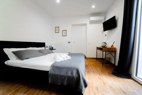 a bedroom with a bed with white sheets and a television at Civico64 apartments in Castellammare del Golfo