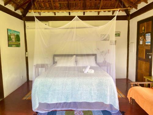 a bedroom with a bed with two towels on it at Casa Tambor Paraty in Paraty