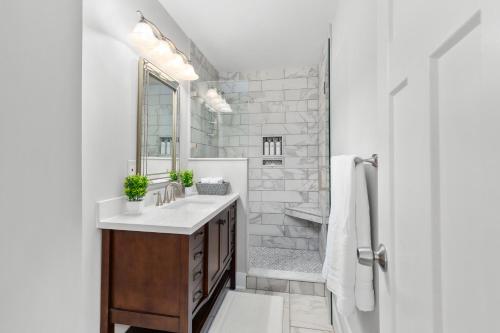 Baño blanco con lavabo y espejo en Charming Modern 3-Bedroom Home in East Nashville! en Nashville