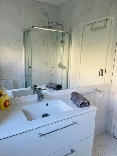 a bathroom with a sink and a large mirror at Lovely Apartment to feel Lisbon in Lisbon