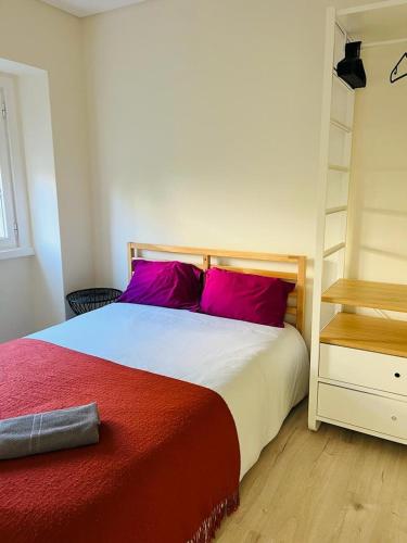 - une chambre avec un lit doté d'oreillers rouges et d'une étagère dans l'établissement Lovely Apartment to feel Lisbon, à Lisbonne