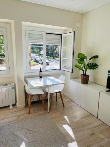 a dining room with a white table and a plant at Lovely Apartment to feel Lisbon in Lisbon