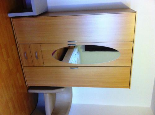 a wooden dresser with a mirror on top of it at Gästehaus Waldmohr in Waldmohr