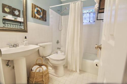a bathroom with a toilet and a sink and a shower at Parrot Head Tiki in Stuart